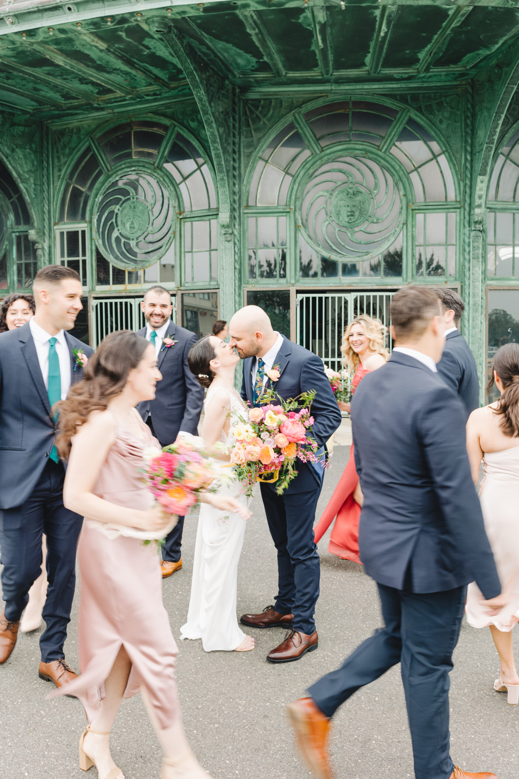 bride and groom kiss in front of asbury park carousel building