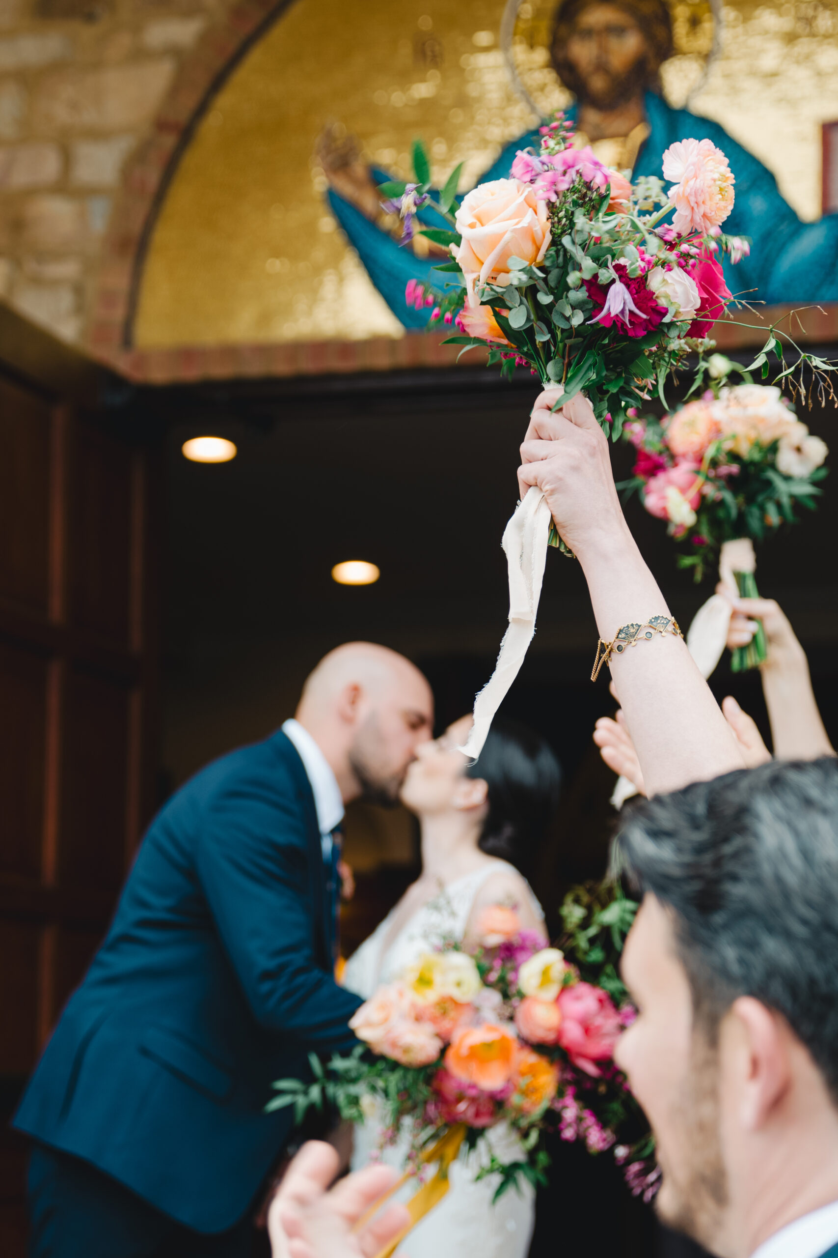 bouquet in air as bride and groom exit church