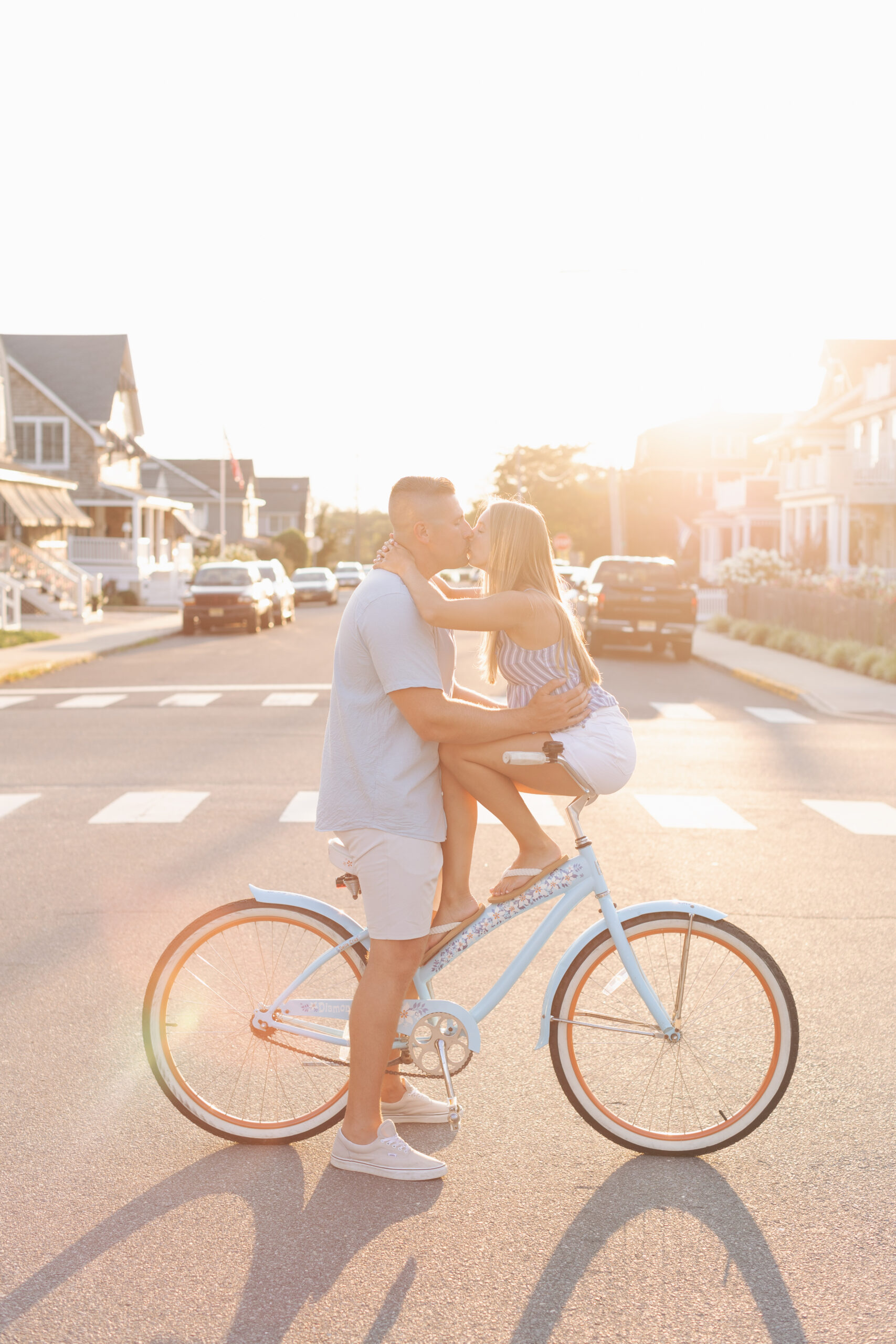 bay head beach engagement couple kissing on bicycle at sunset