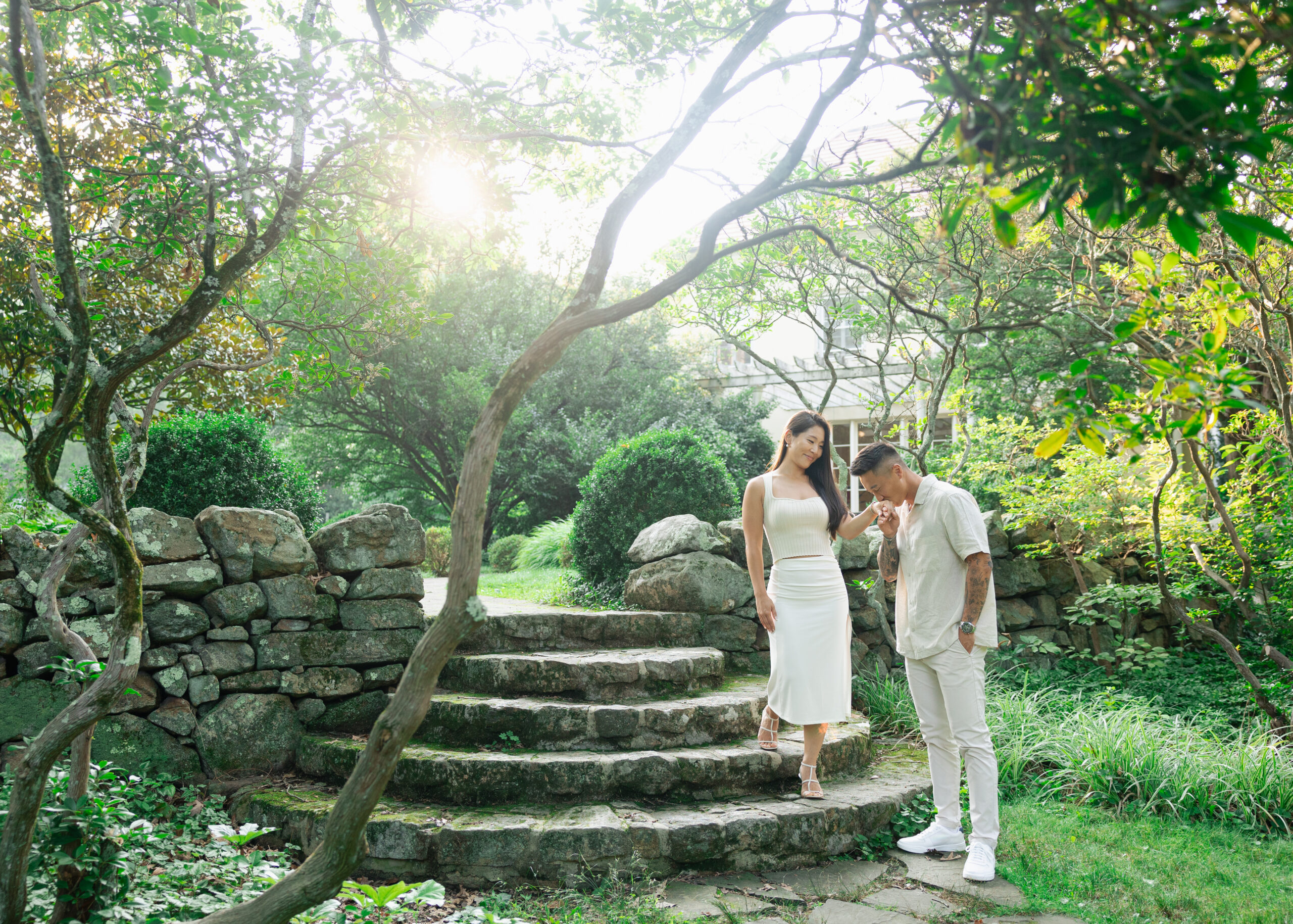 couple in cross estate gardens walking down stone steps

