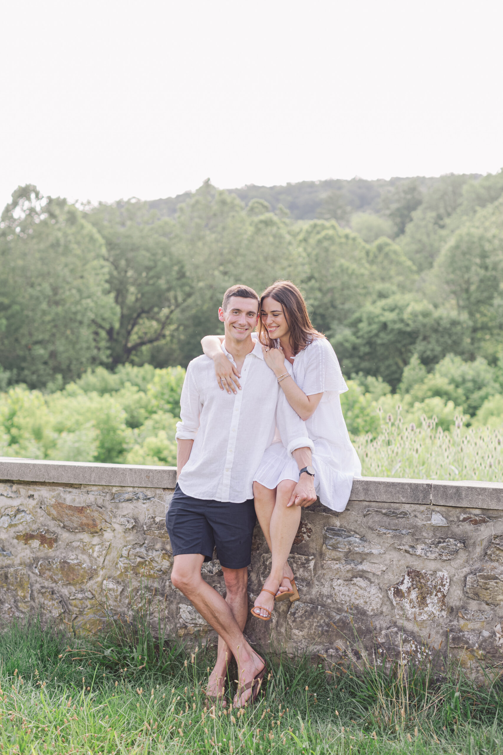 valley forge park engagement couple sitting on stone wall